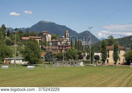 View Village Center Of Magliaso With The Beautiful Church, Some Old Traditional Houses And The Monte