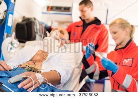 Sjuk patient med ambulanspersonal i ambulans behandling stöd Nödarbete