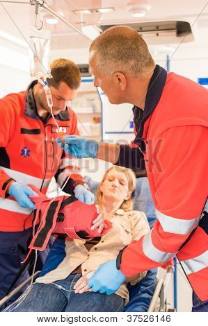 Paramédicos en la ambulancia tratamiento de intervención de emergencia de paciente brazo roto