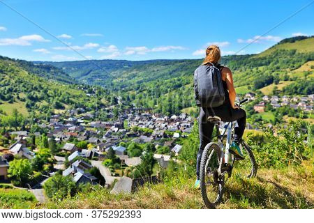 active woman biking countryside- Aveyron in France