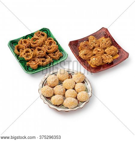 Dish with Moroccan festive homemade chebakia and coconut cookies isolated on white background