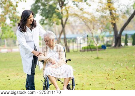 Doctor Help And Care Asian Senior Or Elderly Old Lady Woman Patient Sitting On Wheelchair At Park In