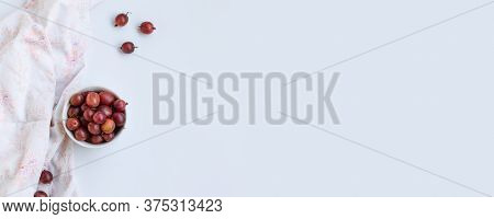 Bowl With Gooseberry On A Grey Background With Copy Space. Top View, Flat Lay