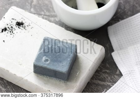 Handmade Soap With Activated Carbon On Marble, Carbon Powder And A Cotton Towel On A Gray Background