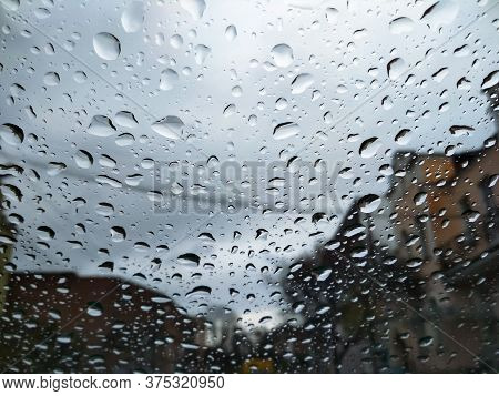 City Street Seen Through Rain Drops On The Car Windshield. Bad Autumn Weather In Rainy Day. Windshie