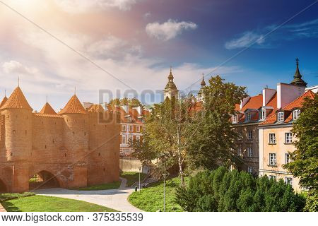 Warsaw, Poland Summer View Of Barbican Or Barbakan Wall And Old Town Houses With Green Trees And Blu