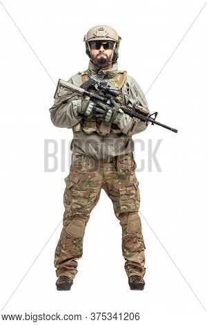 Soldier In Military Equipment With A Shotgun On A White Background, Commando In Uniform With A Weapo