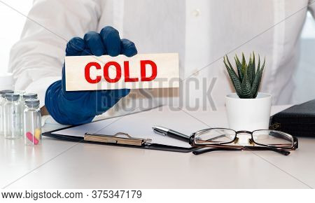A Hand Holding Wooden Letters Spelling Out The Word Cold. Passing On A Virus Concept.