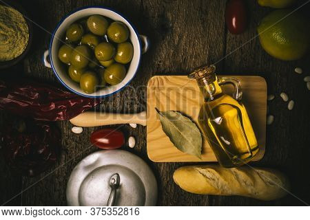 Extra Virgin Olive Oil, Green Olives And Food Ingredients,  Mediterranean Diet On Old Wooden Table.