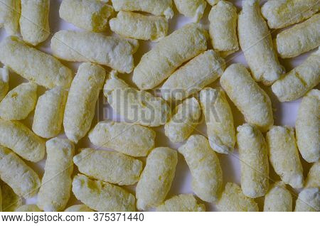 Airy Crisps, Corn Puffs, Puffcorn Snacks Background. Detailed Shot Of Ready-to-eat Puffcorn. Crispy 