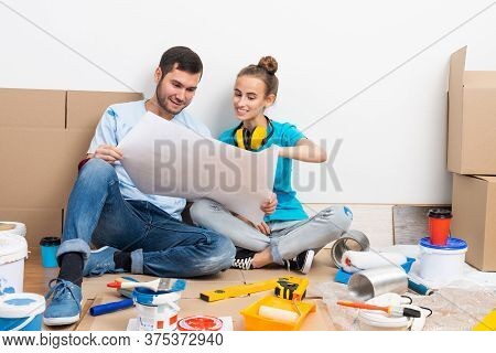 Couple Discussing Home Redesign Ideas. Man And Woman Together Planning New Home Interior Design. Car