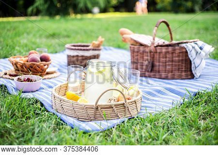 Healthy Vegetarian Picnic With A Delicious Spread Of Fresh Fruit And Bakery Products On Green Grass.