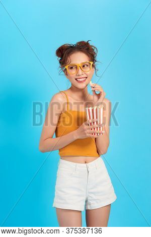 Beautiful  Girl Eat Popcorn And Watch Comedia Movie Isolated On Blue Background
