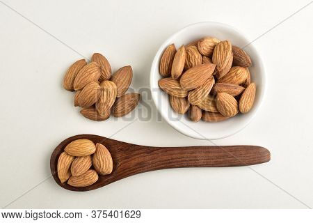 Almonds In Wooden Spoon With Almond Bowl Isolated On White Background, Badam