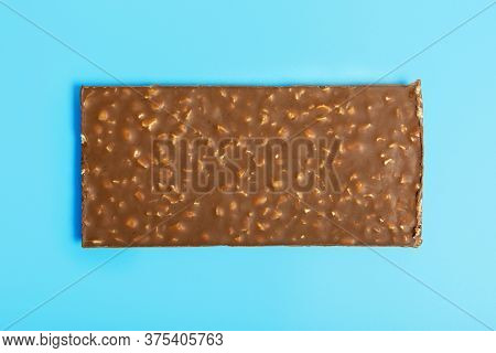 Chocolate Bars With Nuts On A Blue Background. The Concept Of Harmful Sweet Food And Diet. The Conce