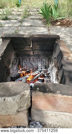 Rustic Mangal Made From Cracked Burnt Terracotta Bricks With Smoky Surface. Flaming Fire Inside Old 