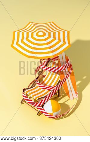 Deck Chair, Umbrella, Surfboard And Ball Are Wound With Protective Signal Tape On The Beach. Concept