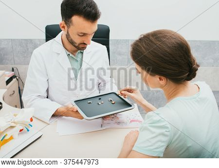 Hearing Solution For Adults. Audiologist Selecting A Hearing Aid For A Caucasian Woman. Patient Need