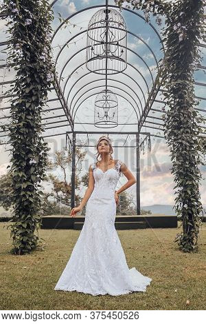Beautiful Bride In Her Wedding Dress Posing For Photos.