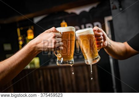Two People Toasting With Mugs Full Of Chopp