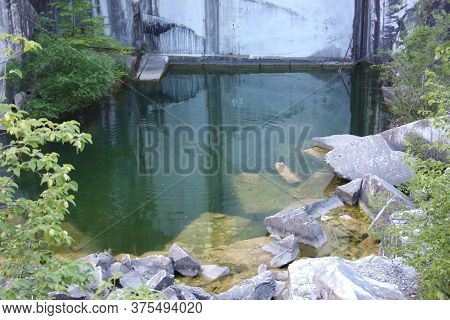 Small Natural Lake Inside A Marble Quarry In Mountain In Apuan Alps