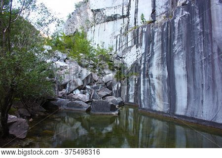 Small Natural Lake Inside A Marble Quarry In Mountain In Apuan Alps
