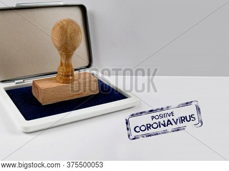 Wooden Stamp On A Desk Positive Coronavirus