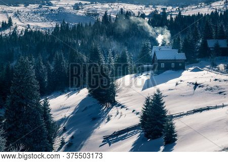 Small Houses With Smoke In The Chimney On A Cold Winter Morning In Marisel, Cluj County, Transylvani