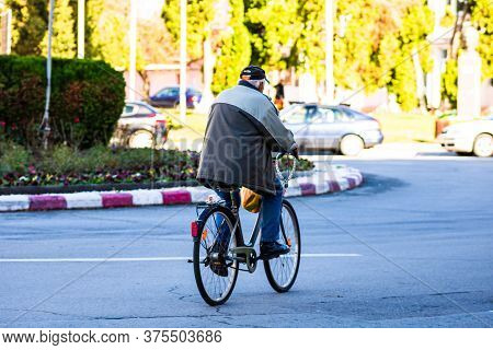 Old Man Riding A Bike In Downtown Of Lugoj, Romania, 2020