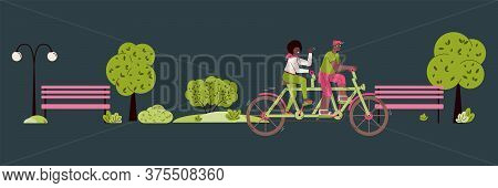 A Couple Rides A Tandem Bike Through An Evening Or Night Park. Happy Man And Woman Are Cycling On Tw