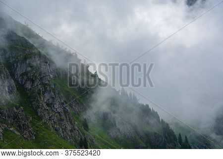 White Clouds, Blue Sky, Green Pastures And Spikes Of Granite Rock In The Lagorai In The Trentino Alp