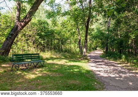A Wooden Park Bench Next To A Hiking Path In Frick Park On A Sunny Summer Day, Pittsburgh, Pennsylva
