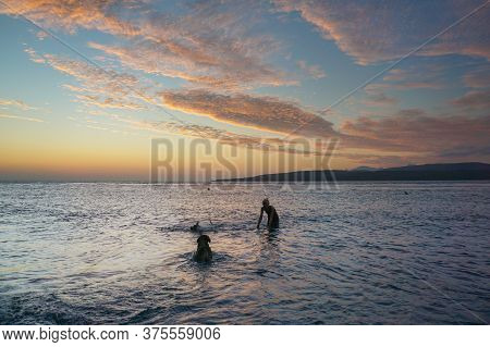 Banyuwangi, Indonesia - July 04, 2020 : A Woman Playing With The Dogs At Watudodol Beach Banyuwangi 
