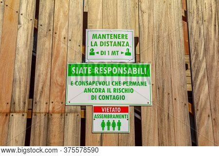 Sansone Beach, Elba Island, Italy - June 17, 2020: Alert Security Sign With Social Distancing Rules 