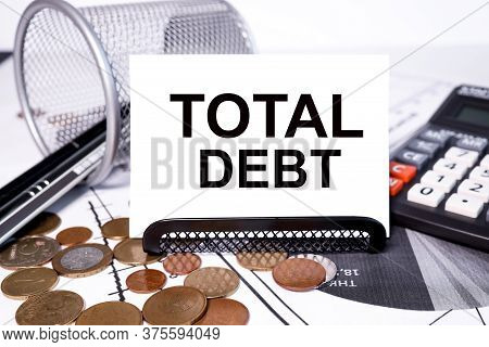 Total Debt Text On A White Background. Near The Calculator And Financial Charts