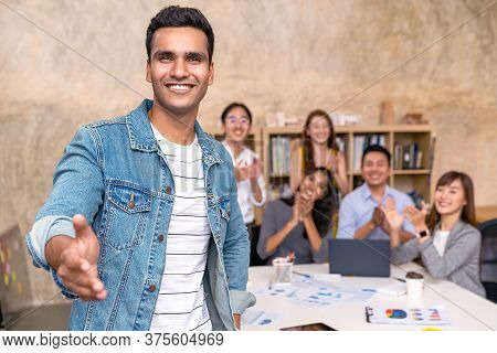 Young Indian Businessman And Team Smile, Look And Give Handshake To Camera At Office In Concept Warm