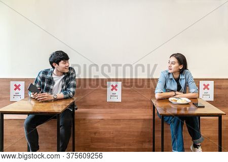 Asian Couple At Seat And Keep Distance Potocol Paper Sign On Seat At Reopenning Restaurant. Arrangem