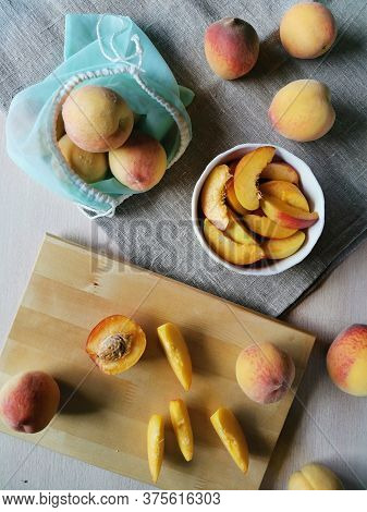Flat Lay Juicy Sliced Peaches In A Plate, Whole Peaches And A Reusable Bag On Burlap