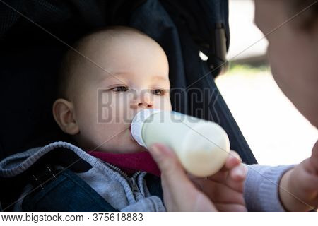 Om Feeding Infant Boy With Drink