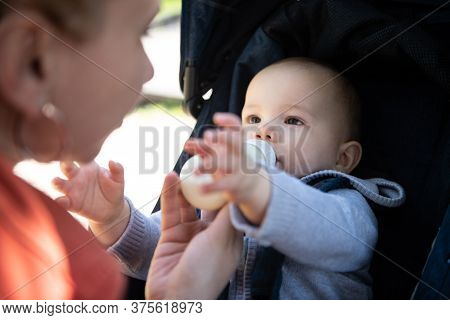 Om Feeding Infant Boy With Drink