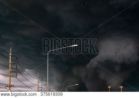 Stormy Sky With Street Light Pole And Three-phase Electric Pylons. Stormy Sky And Dark Clouds. Spotl
