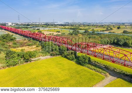 red famous Xilou Bridge over the river and farm in Yunlin county, Taiwan