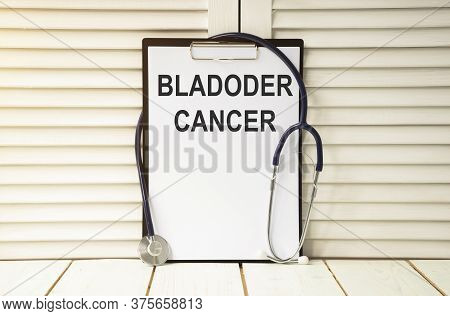 Holding Clipboard With Bladder Cancer Text On A Sheet Of Paper On White Background