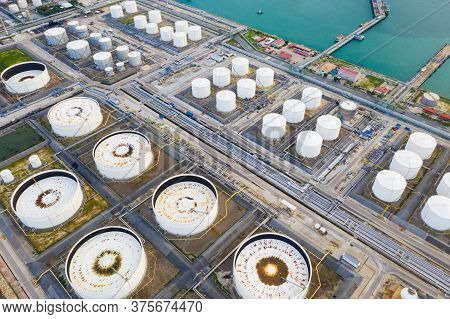 Aerial View Of Oil Refinery Plant Chemical Factory And Power Plant With Many Storage Tanks And Pipel