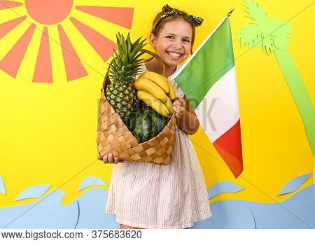Little Girl On A Bright Background With The Italian Flag Holding A Fruit Basket In Her Hands. The Co