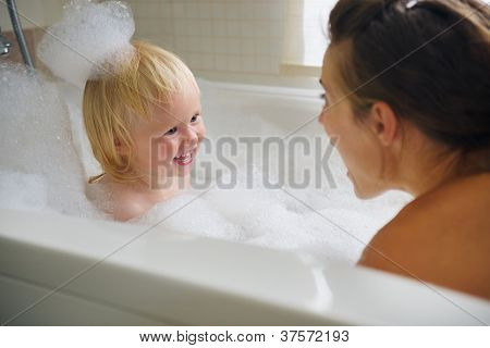 Mutter und Baby Bad zu nehmen und das Spiel mit Schaum