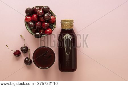 Cold Cherry Juice In A Glass And Bottle With Ripe Berries. Top View, Copy Space For Text. The Concep