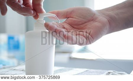 Man Disinfecting His Hands With Disinfectant Liquid Pumped From A Spray Recipient, Cleaning His Skin