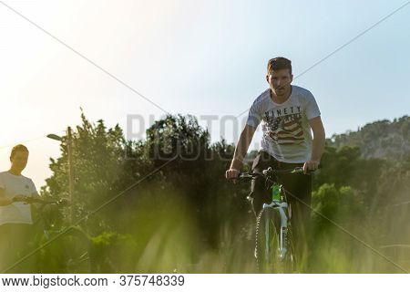 Split,croatia May 2020 Man Intensly Pedalling Towards The Camera Placed On The Ground In Tall Grass.