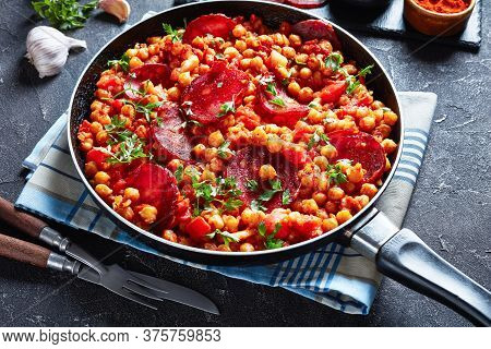 Close-up Of Garbanzos Fritos, Hot Chickpea Stew With Sliced Chorizo, Ham, Tomatoes And Spices In A S